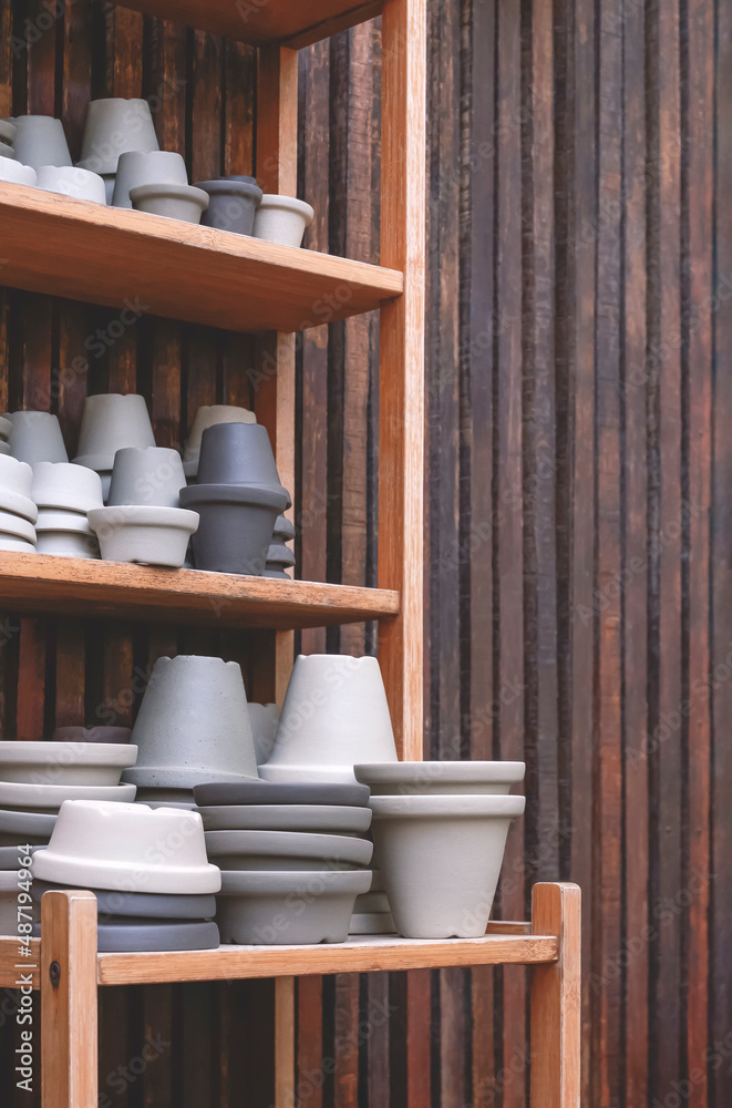 Group of vintage gray terracotta plant pots for sale on wooden shelf ...