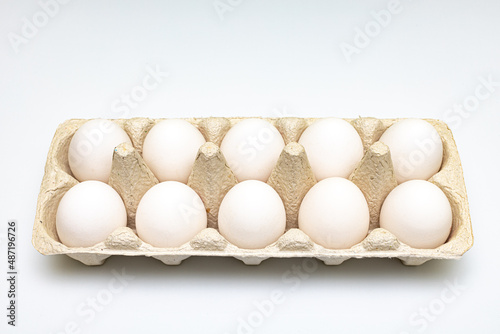 a dozen white eggs lie in a cardboard store package photo