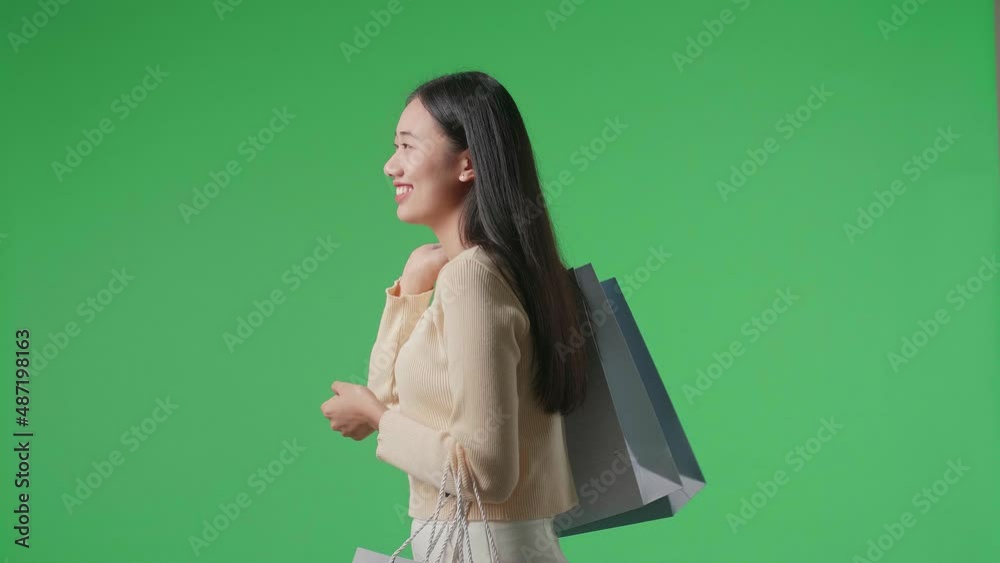 Side View Of An Asian Shopping Woman With Shopping Bags Smile And Walking In Front Of Green Screen
Side View Of An Asian Shopping Woman With Shopping Bags Smile And Walking In Front Of Green Screen