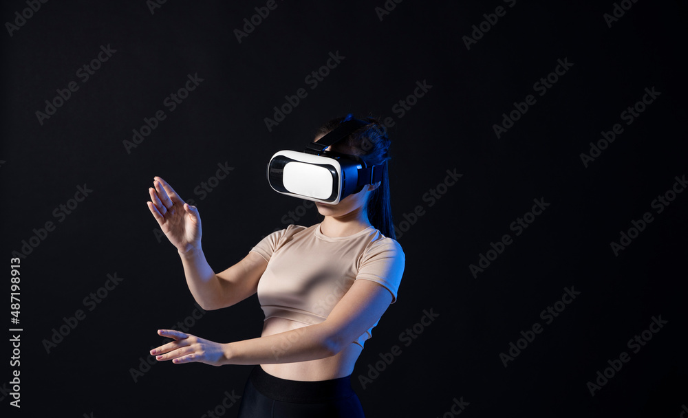 Woman architector using virtual reality glasses at workplace and working with a new project. Woman working in VR goggles in neon light. Designer working in VR studio.