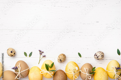 Photography Easter eggs with flowers on a white table.