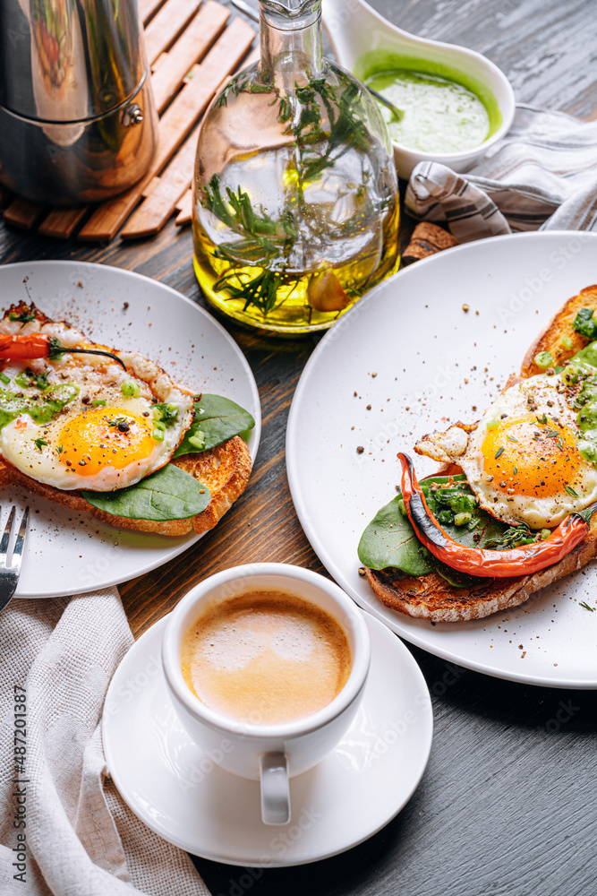 hearty and high-calorie breakfast. delicious and mouth-watering bruschetta with fried eggs and herbs for breakfast with a cup of aromatic coffee. hearty and high-calorie breakfast. delicious and mouth-watering bruschetta with fried eggs and herbs for breakfast with a cup of aromatic coffee.