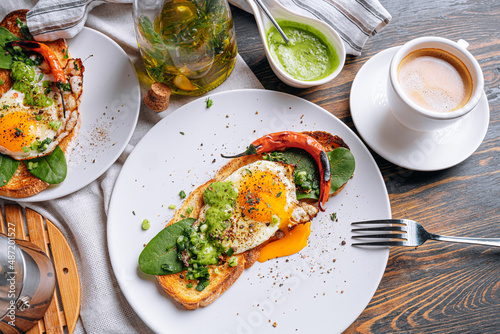 hearty and high-calorie breakfast. delicious and mouth-watering bruschetta with fried eggs and herbs for breakfast with a cup of aromatic coffee.