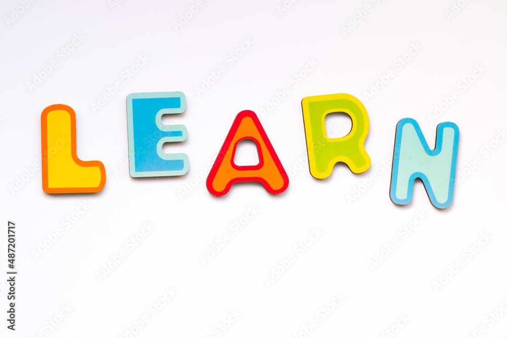 Learn word made of colorful wooden toy letters. School alphabet on white background.