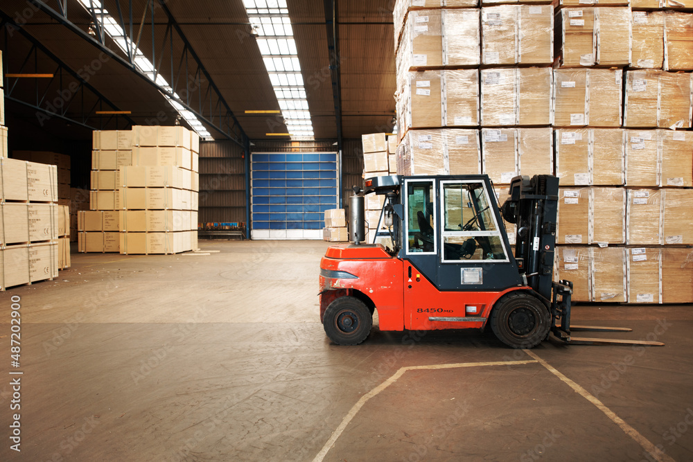 Our service is shipping good. A large warehouse storing big wooden boxes with a forklift.