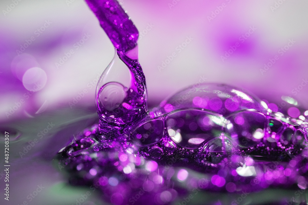 Close-up of abstract, purple water splash, drops on a blurred background Close-up of abstract, purple water splash, drops on a blurred background