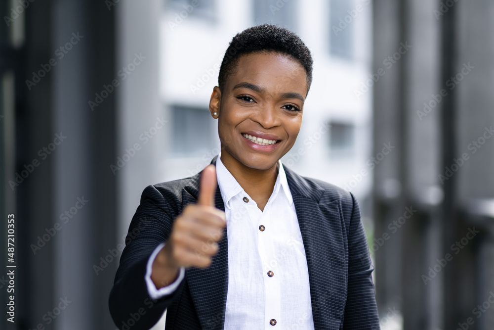 Smiling young black business woman giving thumbs up Smiling young black business woman giving thumbs up