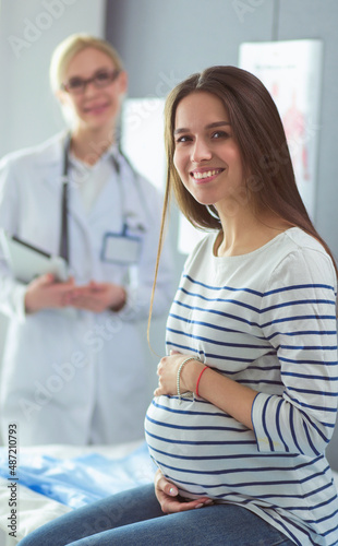 Beautiful smiling pregnant woman with the doctor at hospital