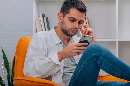 attractive man at home looking at mobile phone