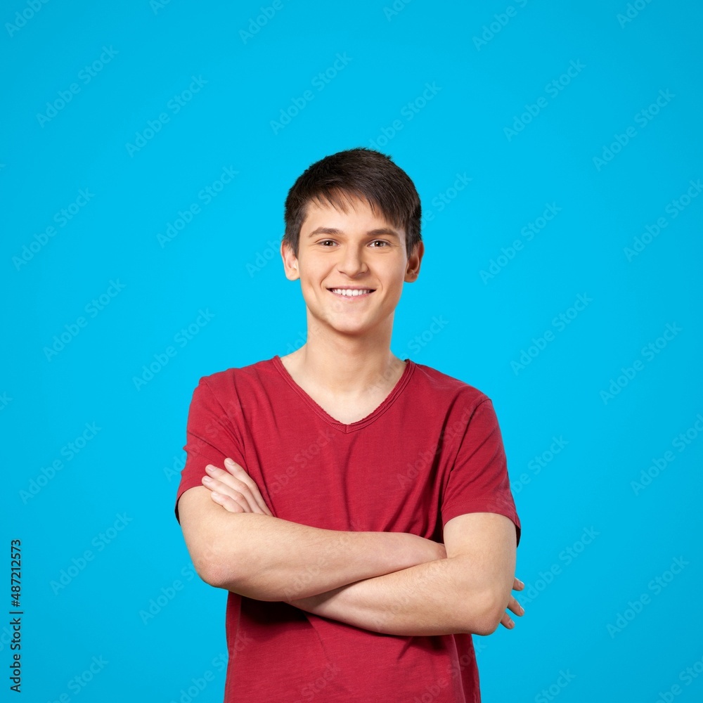 Cheerful Guy Smiling To Camera Posing Crossing Hands Standing Over Background. Cheerful Guy Smiling To Camera Posing Crossing Hands Standing Over Background.