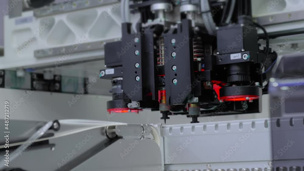 Assembly of printed circuit board - automatic SMT pick and place machine installing SMD electronic components. Industrial, robotic, production, technology and manufacturing concept Assembly of printed circuit board - automatic SMT pick and place machine installing SMD electronic components. Industrial, robotic, production, technology and manufacturing concept