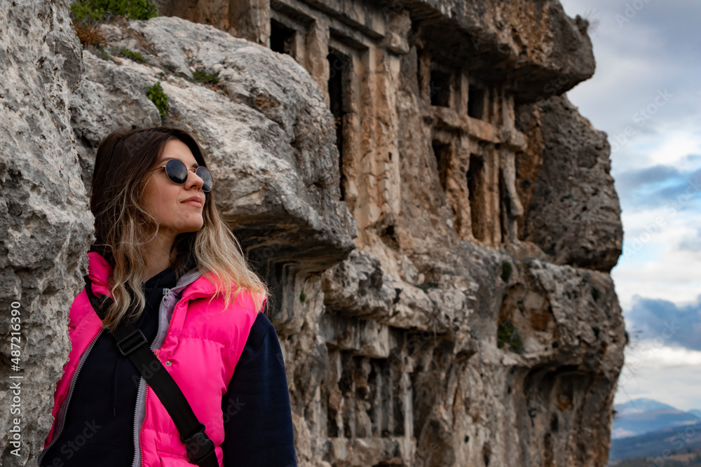 Tlos ancient city from Fethiye, Turkey. Young woman is standing on ruins and looking side. 
