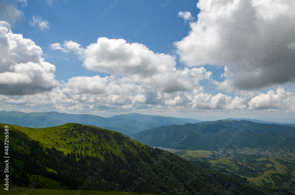 Aerial view from mountain range of rural landscape of the Carpathian Mountains with village in the valley