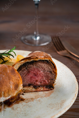 beef wellington portion with potatoes close up