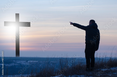 Cross. Crucifixion, Jesus. Silhouette, Man near the cross. Prayer, repentance for sin. Glorification of God. Easter illustration. photo