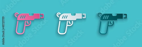 Paper cut Pistol or gun icon isolated on blue background. Police or military handgun. Small firearm. Paper art style. Vector