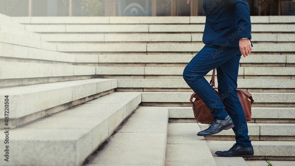 Climbing the steps to success. Profile shot of an unidentifiable businessman walking to work in the city. Climbing the steps to success. Profile shot of an unidentifiable businessman walking to work in the city.