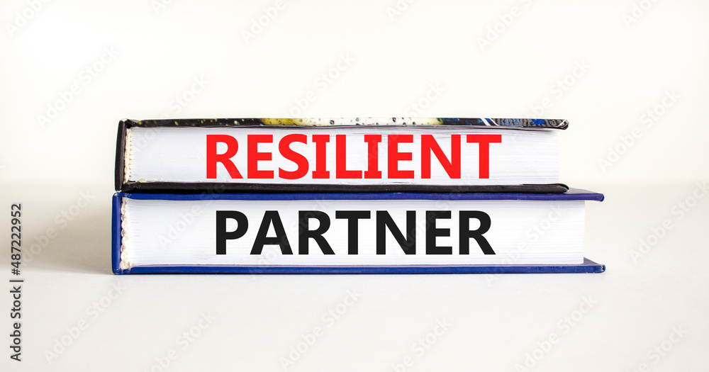 Resilient partner symbol. Concept words Resilient partner on books on a beautiful white table white background. Business resilience and resilient partner concept, copy space.