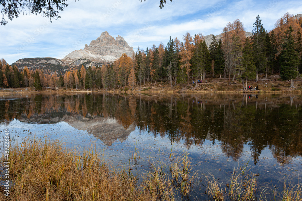 Autumnal trees on Lake Antorno, with the Tre Cime di Lavaredo in the background and reflected on water, Dolomites, Italy Autumnal trees on Lake Antorno, with the Tre Cime di Lavaredo in the background and reflected on water, Dolomites, Italy