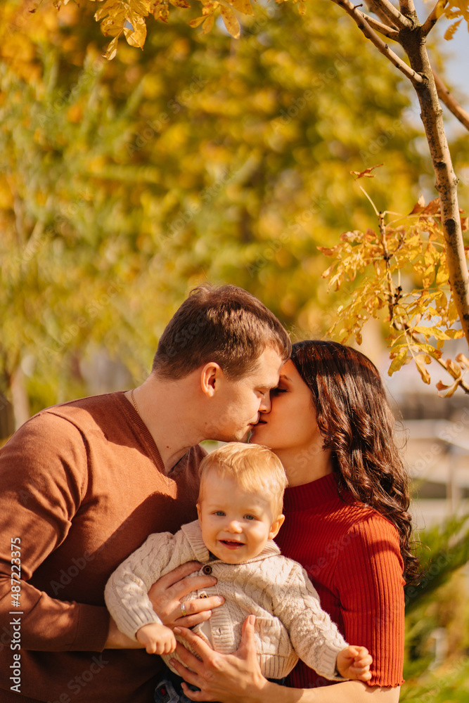 a portrait of happy family with a small child on an autumn walk. a portrait of happy family with a small child on an autumn walk.