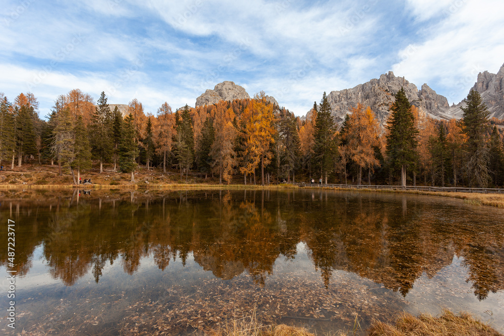 Reflection of autumnal larches and firs on Lake Antorno, with Cadini di Misurina in the background, Dolomites, Italy