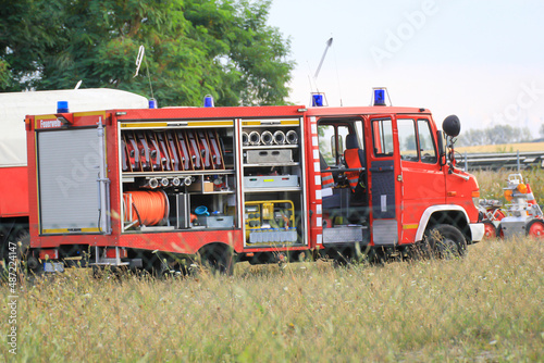 Ein Feuerwehrauto mit geöffneter Seite. Viele Schläuche und andere Ausrüstungsgegenstände.
