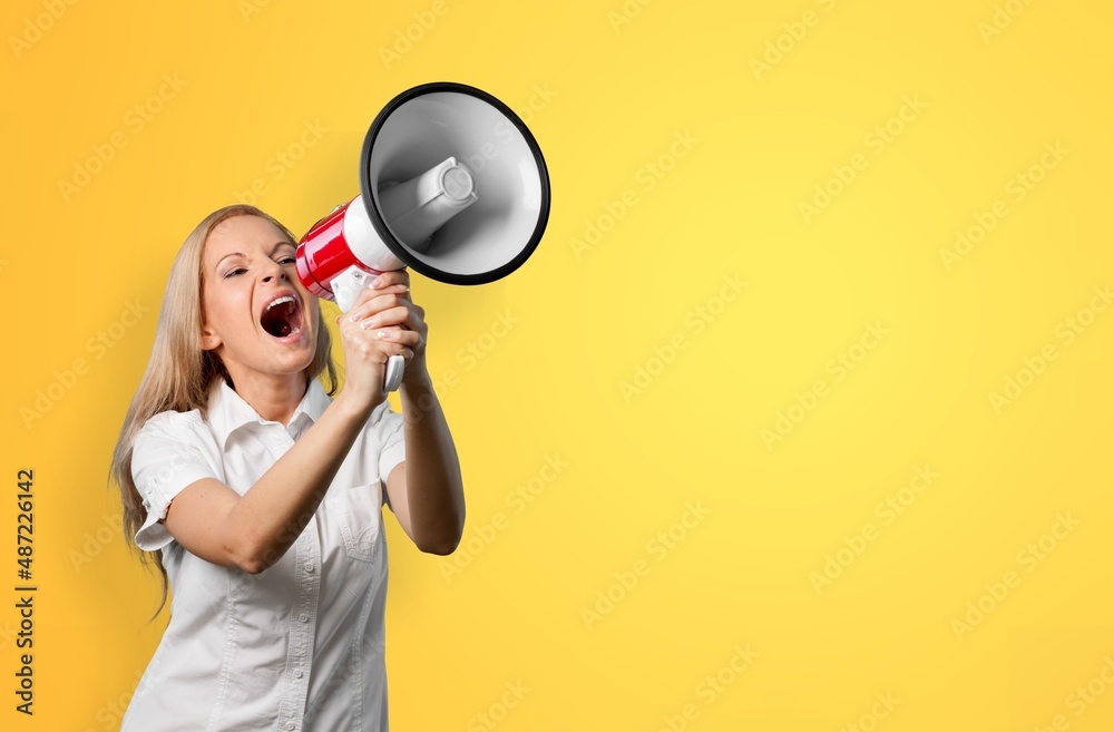 Excited beautiful woman talking seriously holding megaphone in hands Excited beautiful woman talking seriously holding megaphone in hands