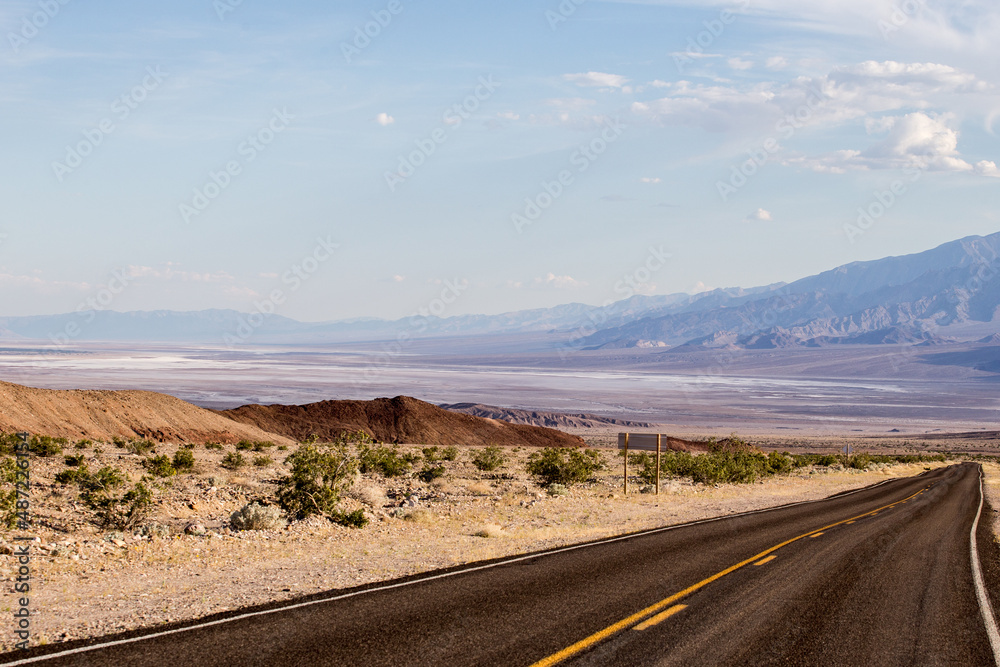 Empty road to the mountains in the desert, solitude on a road trip in the USA
