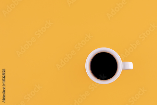 cup of americano coffee on a yellow background. Space for text.