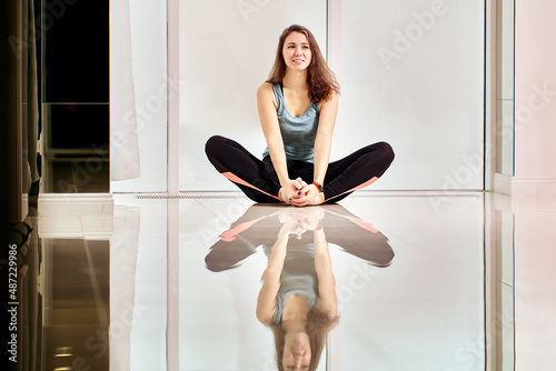 Warm floor with smiling woman who makes exercises during training inside.