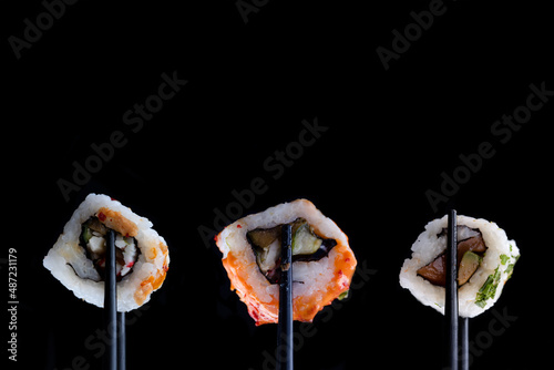 sushi with black chopsticks on black background