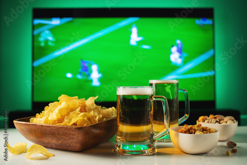 Fototapeta Beer and snacks set on football match tv background