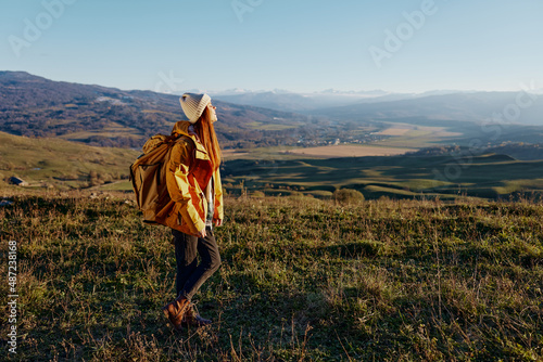 woman traveler backpacking trip to mountains landscape sunny day