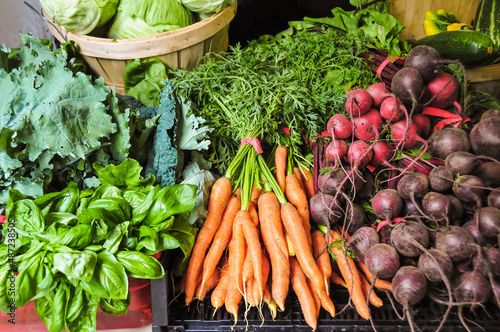 A large bunch of fresh a variety of colorful vegetables at a Farmer s Market. Beets  carrots  lettuce.