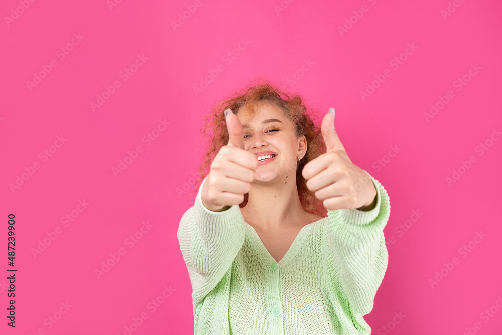 Close-up portrait of attractive surprised girl, showing thumbs up gesture. Success luck concept. Close-up portrait of attractive surprised girl, showing thumbs up gesture. Success luck concept.
