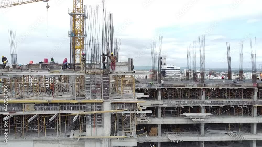 Vuelo aéreo con giro 180 grados captando obreros trabajando proyecto inmobiliarios, con fondo de la cuidad urbana de santo domingo Vuelo aéreo con giro 180 grados captando obreros trabajando proyecto inmobiliarios, con fondo de la cuidad urbana de santo domingo