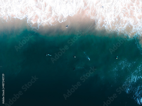 Vista aérea de agua cristalina y surfers photo