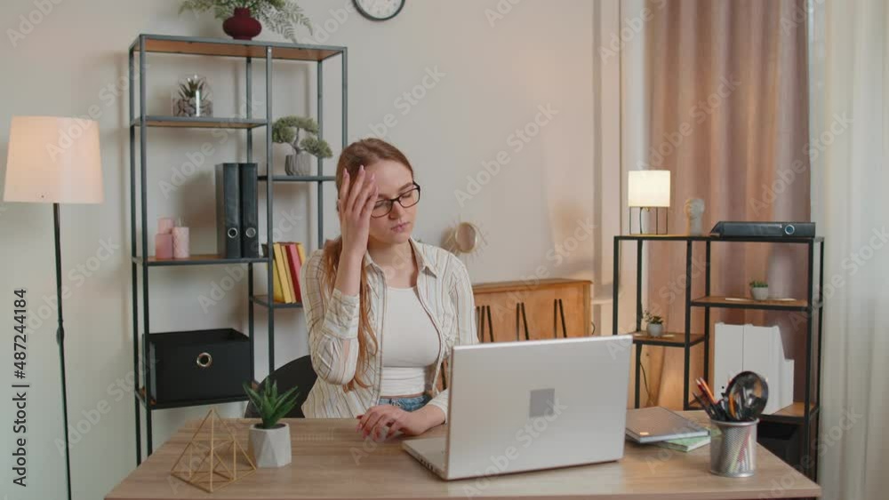 Tired woman freelancer using laptop computer, suffering from tension, migaine headache, sitting at table working from home office. Adult girl businesswoman e-learning, browsing internet, remote job Tired woman freelancer using laptop computer, suffering from tension, migaine headache, sitting at table working from home office. Adult girl businesswoman e-learning, browsing internet, remote job
