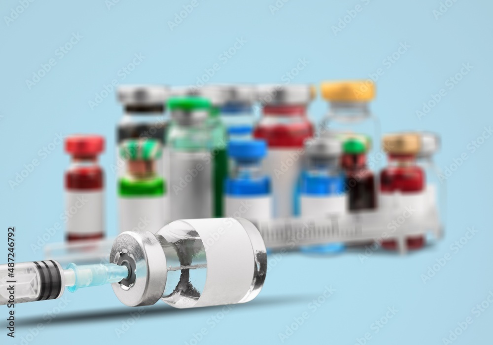 COVID-19 Vaccine vials, Original vaccine vials with a syringe on blurred background COVID-19 Vaccine vials, Original vaccine vials with a syringe on blurred background