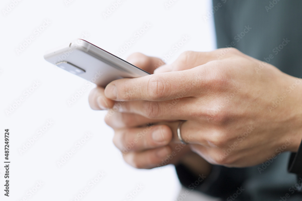 スマートフォンでテキスト入力をするアジア人の男性 スマートフォンでテキスト入力をするアジア人の男性