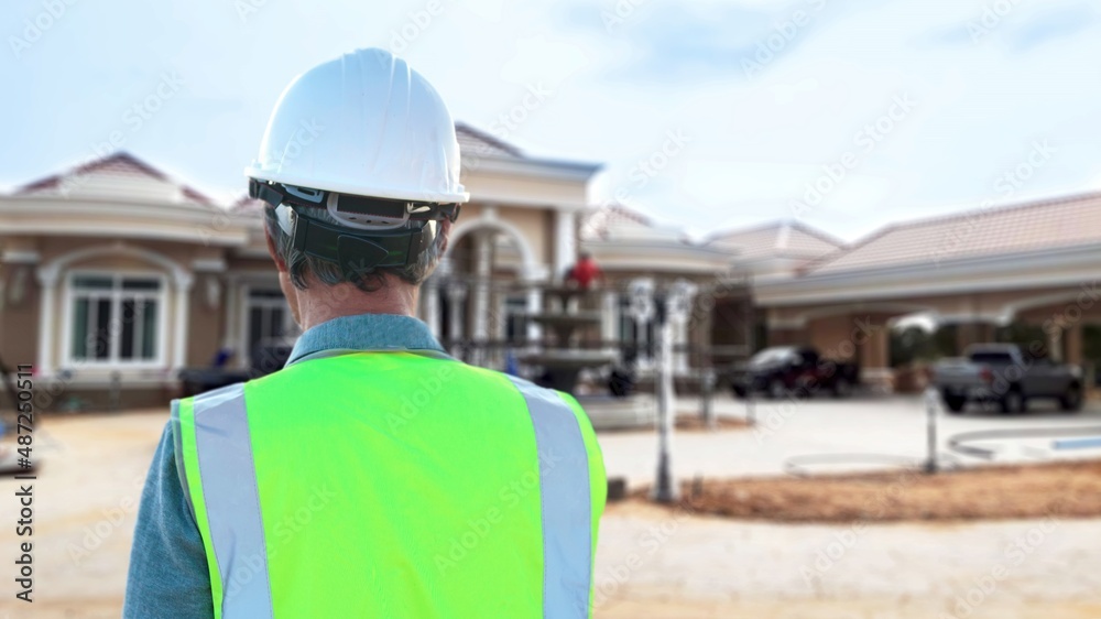 Behind the scenes of a senior architect wearing a helmet and safety vest, there is a scene of a construction site. Behind the scenes of a senior architect wearing a helmet and safety vest, there is a scene of a construction site.