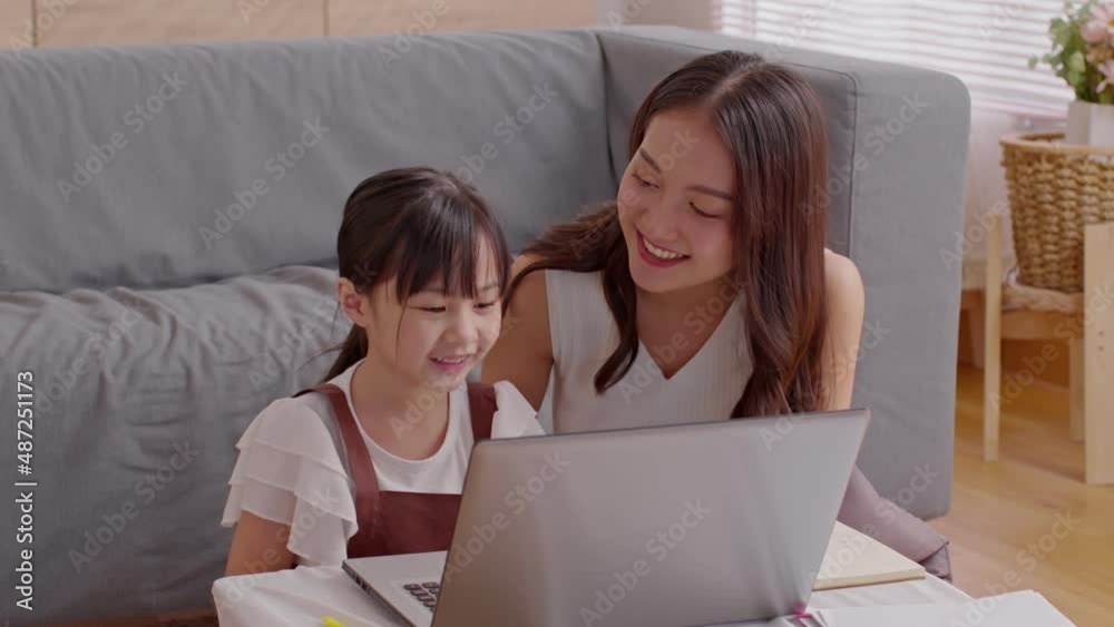 Asian young mother and her daughter have video call conference with family having fun together.Happiness Mom and little girl looking at mobile phone and waving hand with video chat to grandmother Asian young mother and her daughter have video call conference with family having fun together.Happiness Mom and little girl looking at mobile phone and waving hand with video chat to grandmother