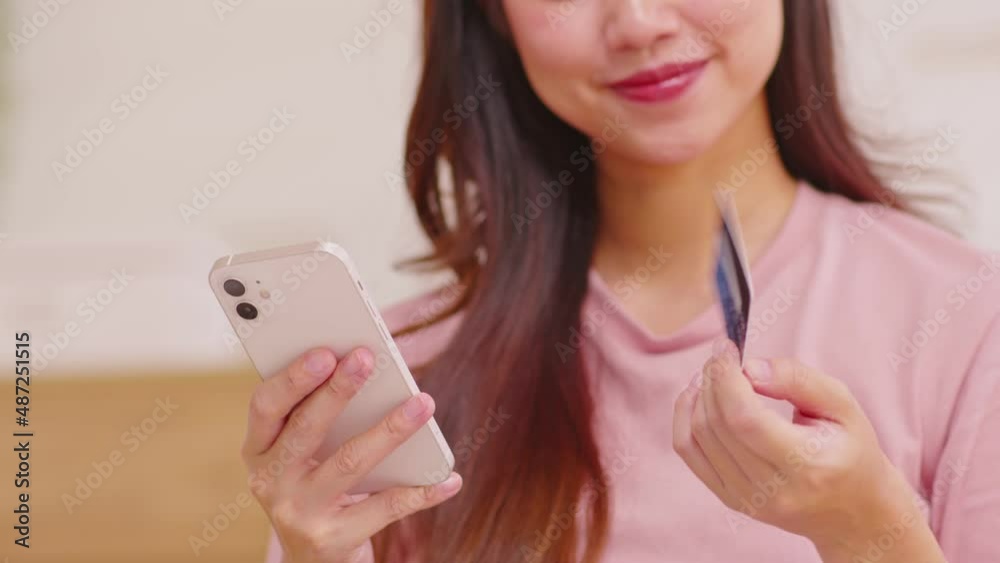 Close up Asian young woman using credit card for pay online shopping on mobile phone.Hand typing credit card number to buying cloths from internet online store.Digital payment technology concept Close up Asian young woman using credit card for pay online shopping on mobile phone.Hand typing credit card number to buying cloths from internet online store.Digital payment technology concept