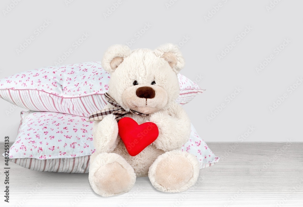 White cotton square baby pillow with toy on the desk White cotton square baby pillow with toy on the desk
