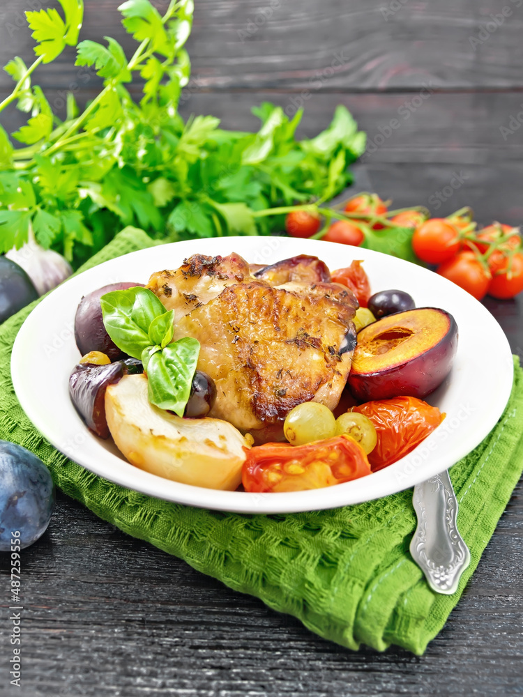 Chicken with fruits and tomatoes in plate on napkin