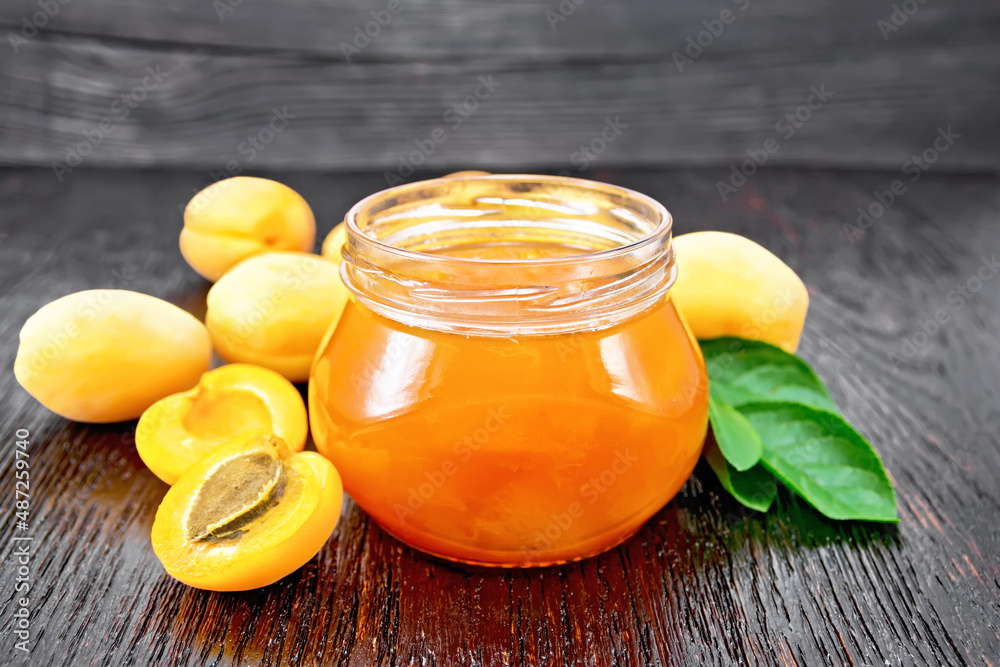 Jam apricot in jar on dark board Jam apricot in jar on dark board