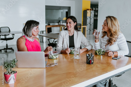 latin business women middle age eating salad at the office terrace in Mexico Latin America	 photo