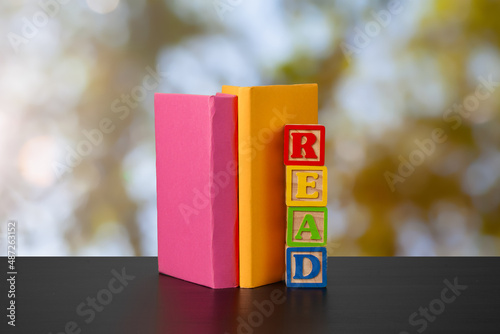 Stack of books on wooden table against blurred background