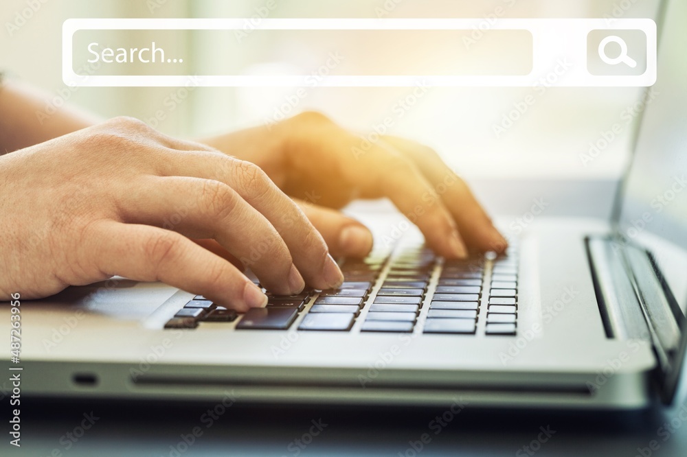 People hand using laptop or computer searching for information with search box icon.