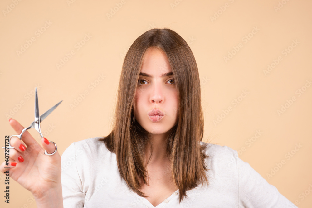 Woman with scissors having hair cut. Close up of a young woman with beautiful hair hold scissors, yellow background. Woman with scissors having hair cut. Close up of a young woman with beautiful hair hold scissors, yellow background.